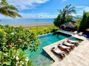 an aerial view of a pool with chairs and the beach at Paradise West-Bali in Palasari