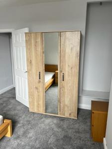 Nice 2Bedroom house for Family في نوتينغهام: غرفة مع خزانة خشبية مع سرير