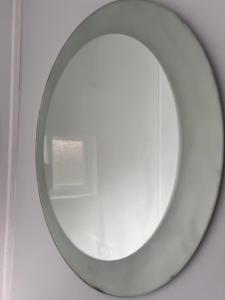 a round mirror on a wall with a window at Nice 2Bedroom house for Family in Nottingham