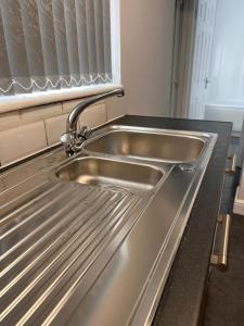 a stainless steel sink in a kitchen with a window at Nice 2Bedroom house for Family in Nottingham