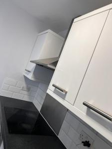 a kitchen with white cabinets and a sink at Nice 2Bedroom house for Family in Nottingham