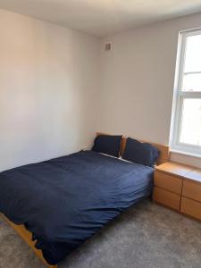 a bedroom with a blue bed and a window at Nice 2Bedroom house for Family in Nottingham