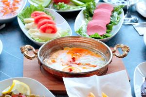 a bowl of food on a table with plates of food at Vizyon Otel Darıca in Darıca