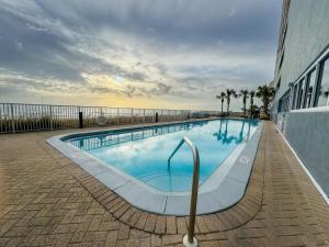 une grande piscine avec l'océan en arrière-plan dans l'établissement Ocean Reef 808, à Panama City Beach