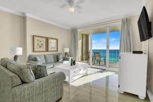 - un salon avec un canapé et une table offrant une vue sur l'océan dans l'établissement Ocean Reef 808, à Panama City Beach