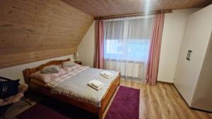 a bedroom with a bed and a large window at Zielona Przestrzeń in Polańczyk