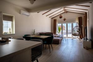 a living room with a couch and a table and chairs at Villa Bohemica with Private Heated Pool in Orebić