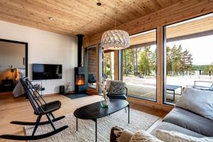 ein Wohnzimmer mit einem Sofa und einem Tisch in der Unterkunft Saunamaki Resort F - Beachfront in Salo