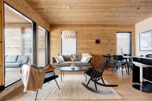 ein Wohnzimmer mit einem Sofa und einem Tisch in der Unterkunft Saunamaki Resort F - Beachfront in Salo