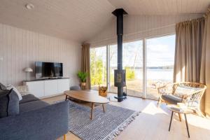 a living room with a couch and a table and a fireplace at Stay North - Villa Katajala in Hämeenlinna