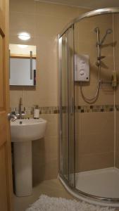 a bathroom with a glass shower and a sink at The Westwoods in Westwood