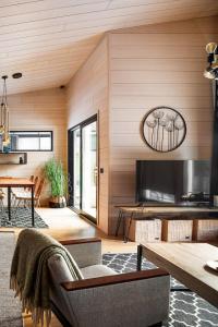 a living room with a table and a television at Villa Ritva - Modern - Lakefront - Hot Tub in Hyvinkää