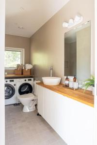 a bathroom with a sink and a washing machine at Stay North - Villa Katajala in Hämeenlinna