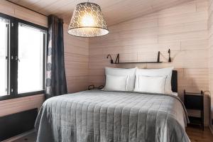 a bedroom with a bed and a light fixture at Villa Ritva - Modern - Lakefront - Hot Tub in Hyvinkää