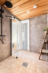 um quarto com uma porta de vidro e um tecto de madeira em Villa Ritva - Modern - Lakefront - Hot Tub em Hyvinkää