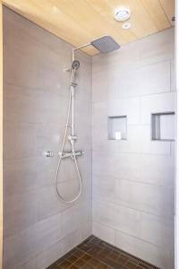La salle de bains est pourvue d'une douche avec un pommeau de douche. dans l'établissement Stay North - Villa Katajala, à Hämeenlinna