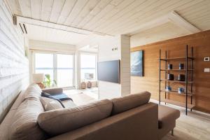 a living room with a couch and a flat screen tv at Stay North - Villa Kalksved in Sipoo