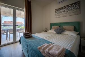 a bedroom with a large bed and a balcony at Villa Bohemica with Private Heated Pool in Orebić +29 photos