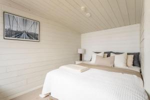 a white bedroom with a bed in a room at Stay North - Villa Kalksved in Sipoo