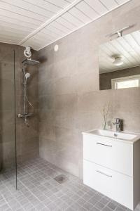La salle de bains est pourvue d'une douche, d'un lavabo et d'un miroir. dans l'établissement Stay North - Villa Kalksved, à Sipoo