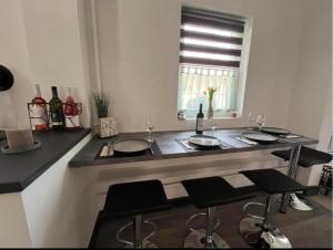 Kiscsillag Apartman في جينيسدياس: مطبخ مع بار مع كراسي وكاسات للنبيذ