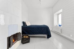 a white bedroom with a bed and a fireplace at Charming Riverside House with Terrace in Turku