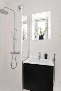 a white bathroom with a sink and a shower at Charming Riverside House with Terrace in Turku