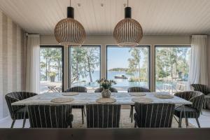 - une salle à manger avec une table, des chaises et des fenêtres dans l'établissement Stay North - Villa Lovo - Perfect Island Retreat, à Espoo