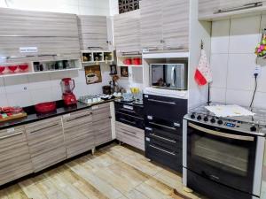 a large kitchen with wooden cabinets and appliances at Casa de campo Domeni rustica e próximo a cidade de Juiz de Fora MG in Juiz de Fora