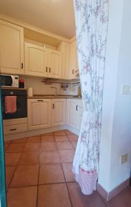 a kitchen with white cabinets and a tile floor at Gest Short Rent Siena 5 in Siena
