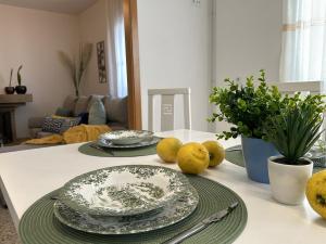 una mesa de comedor con platos y limones. en Casa Marino, en Cambados