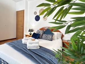 Un dormitorio con una cama con almohadas y una planta en Casa Marino, en Cambados
