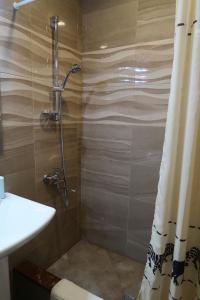 uma casa de banho com um chuveiro e um lavatório. em guest house Merci em Tbilisi