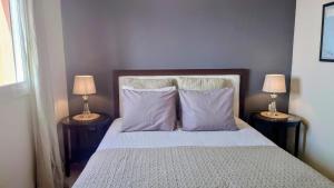 a bedroom with a bed with pillows and two lamps at Carmen Apartamento Millón - Private roof terrace with Jacuzzi & BBQ in Nerja