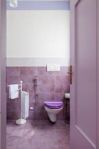 y baño con aseo púrpura y ducha. en REVO Apartments - Casa Viola, en Berbenno di Valtellina