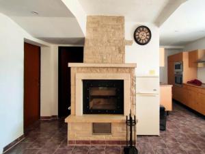 a living room with a stone fireplace with a clock at Skajla Apartments in Medulin