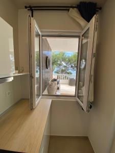 a room with a large window in a house at Beach Apartments Ankora in Makarska