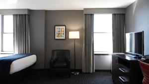 a hotel room with a bed and a television at Roomza Inner Harbor at Lord Baltimore in Baltimore