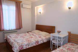 a small bedroom with two beds and a table at guest house Merci in Tbilisi City
