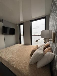 Schlafzimmer mit einem Bett und Blick auf das Wasser in der Unterkunft Houseboat EnergyApart in Stettin
