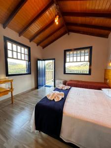 a bedroom with a bed with two towels on it at Estância do Biribiri in Diamantina