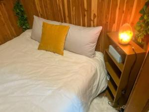 a bed with a yellow pillow and a lamp on it at Long Mountain Suite W/Hot tub in Amherst