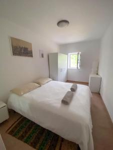 - une chambre avec un grand lit blanc et 2 serviettes dans l'établissement Trullo Pinto, à Locorotondo