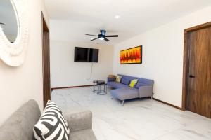 een woonkamer met een bank en een tv bij Casa 4 recamaras, alberca, terraza y club playa. in Cruz de Huanacaxtle