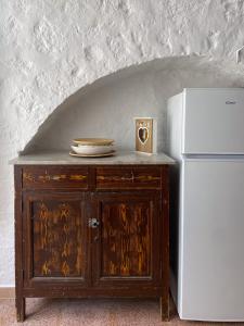 ロコロトンドにあるTrullo Pintoの白い冷蔵庫、木製のキャビネット(皿付)