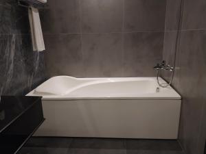a white bath tub sitting in a bathroom at Hotel MERIDIAN in Kary