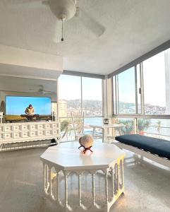 a living room with a table and a tv at Best Location Steps from the Beach in Acapulco