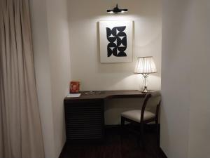 a desk with a lamp and a chair in a room at Hotel MERIDIAN in Kary
