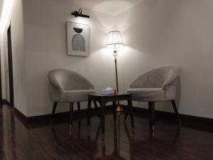 two chairs and a table in a room with a lamp at Hotel MERIDIAN in Kary