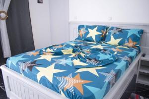 - un lit avec une couette bleue et des étoiles dans l'établissement Studio moderne avec Balcon, à Pointe-Noire